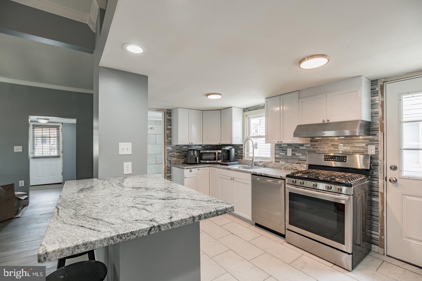 4101 9th Street North Beach, MD 20714 - Photo 6 of 19 a kitchen with kitchen island a stove sink and cabinets
