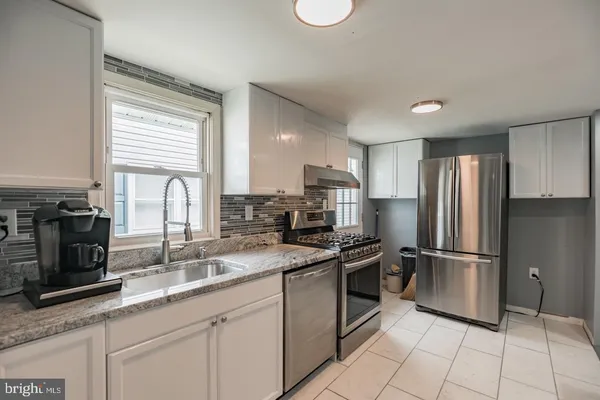 a kitchen with stainless steel appliances granite countertop a stove a sink and a refrigerator