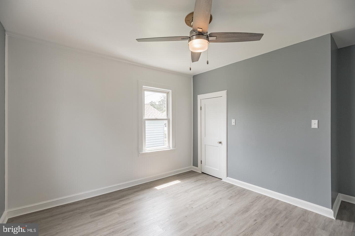 4101 9th Street North Beach, MD 20714 - Photo 9 of 19 an empty room with wooden floor fan and windows