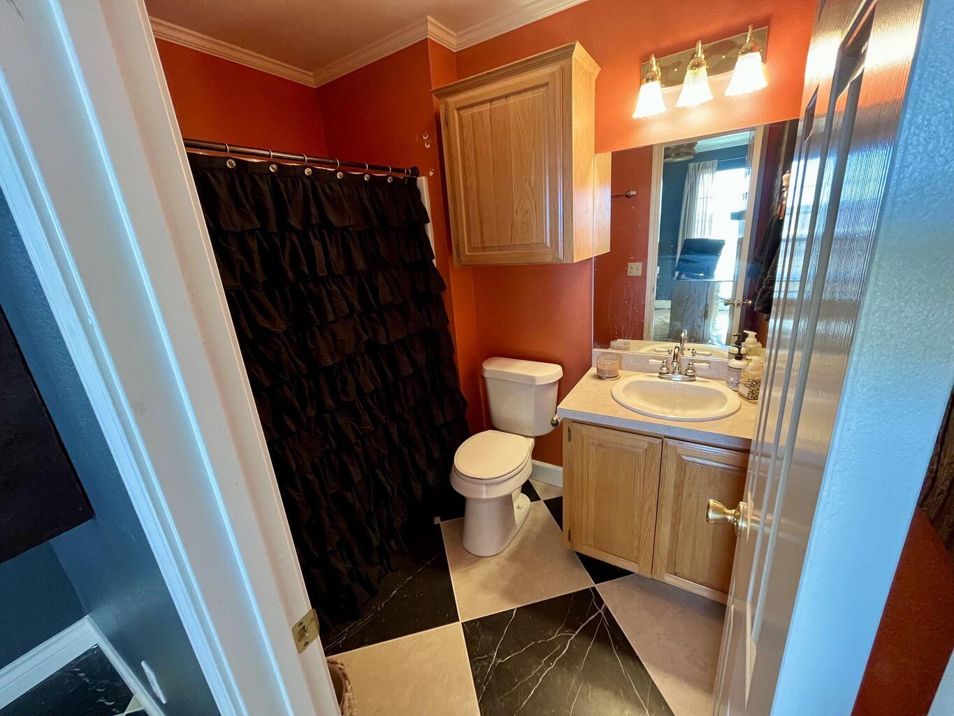 1492 Co Road Hale Center, TX 79041 - Photo 21 of 64 a bathroom with a sink a toilet a mirror and shower curtain