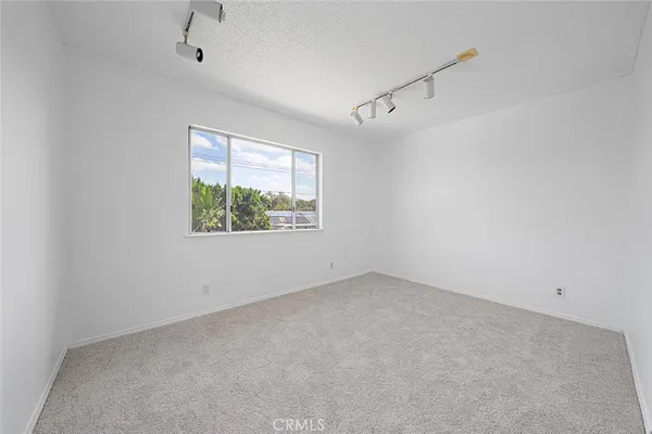 an empty room with a window and a ceiling fan