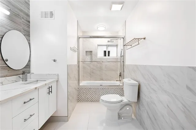 a bathroom with a toilet sink a mirror and vanity