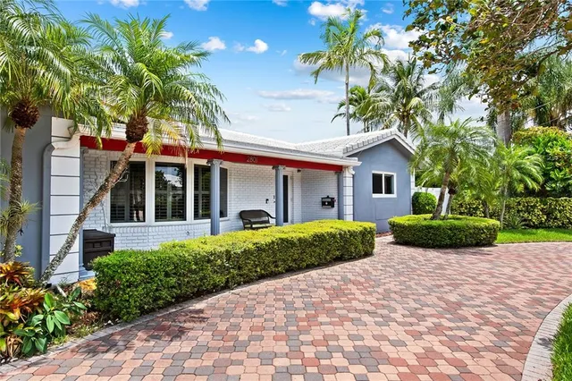 a view of a house with a big yard and palm trees