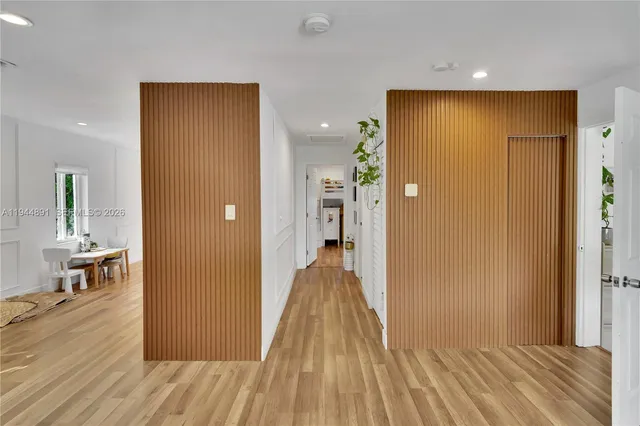 a view of a hallway with wooden floor and dining room