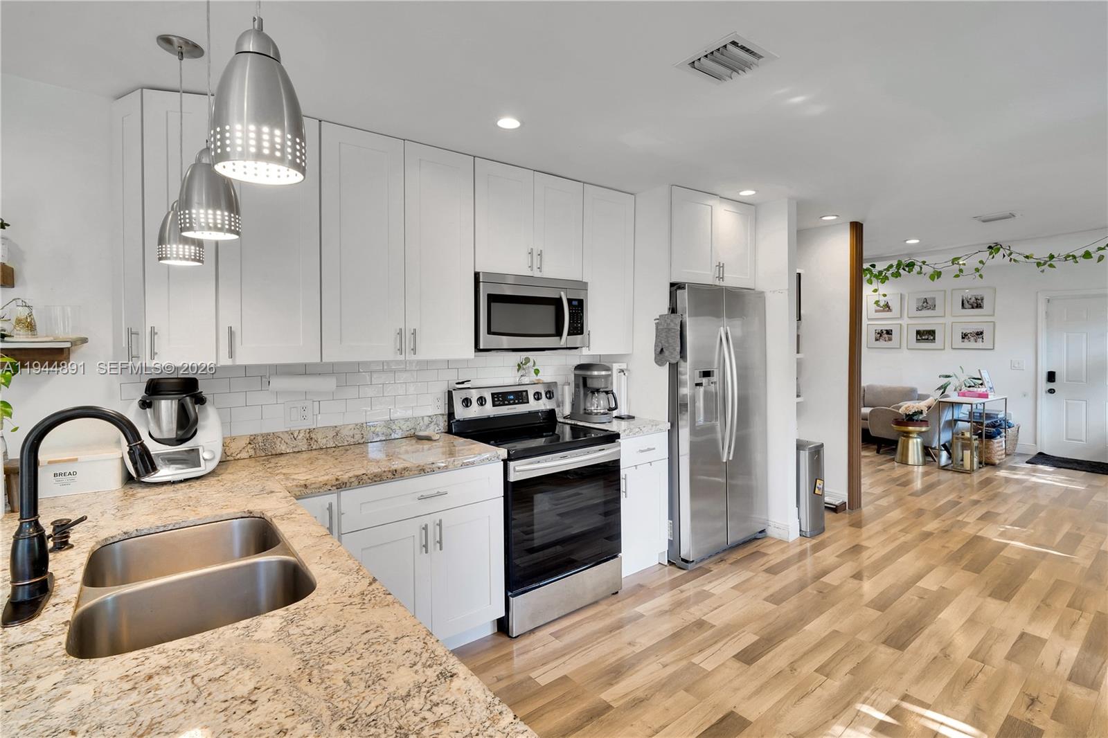 1450 Southwest 20th Avenue Miami, FL 33145 - Photo 14 of 44 a kitchen with granite countertop a sink stainless steel appliances and cabinets
