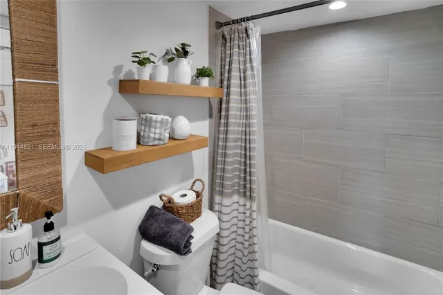 a bathroom with a bathtub shower and toilet