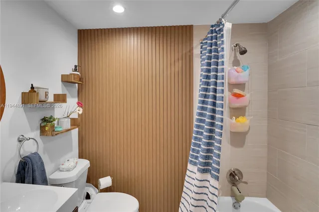 a bathroom with a toilet and shower curtain