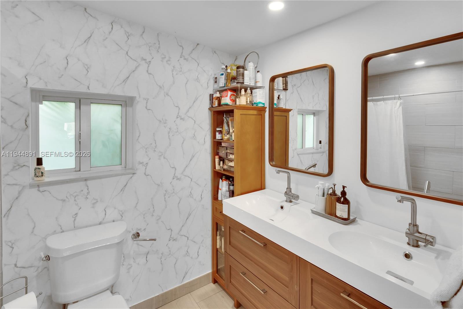 1450 Southwest 20th Avenue Miami, FL 33145 - Photo 33 of 44 a bathroom with double vanity sinks a toilet and a mirror