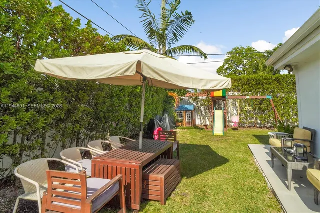 a view of a patio with table and chairs under an umbrella