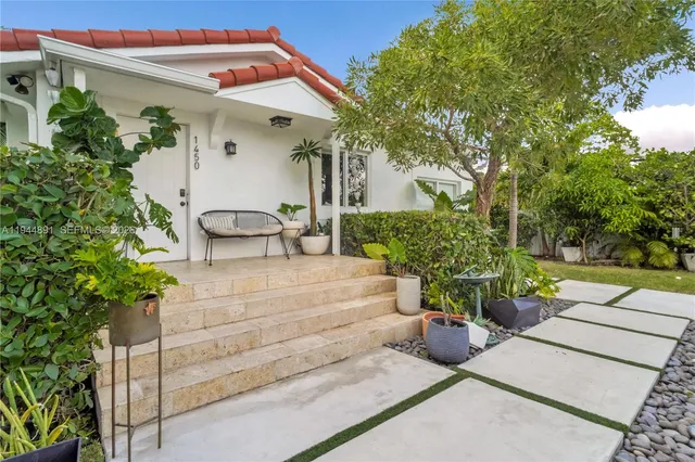a view of a patio with table and chairs potted plants and a large tree