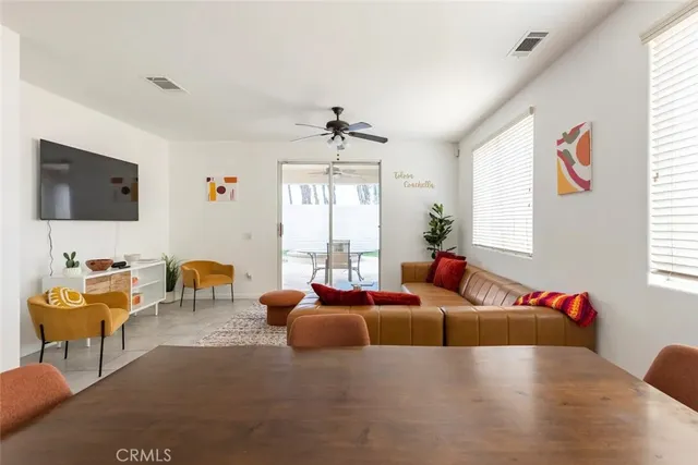 a living room with furniture a flat screen tv and a large window