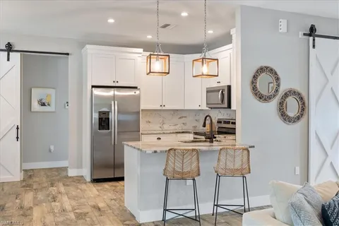 a kitchen with stainless steel appliances granite countertop a refrigerator and a stove top oven