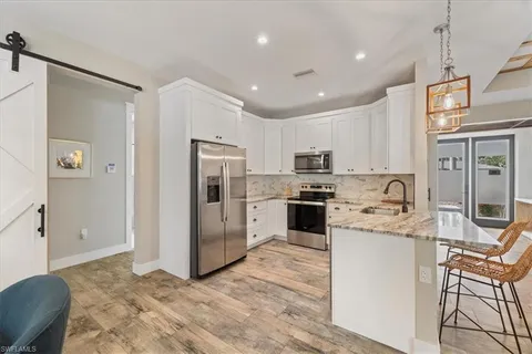 a kitchen with stainless steel appliances granite countertop a refrigerator sink and microwave