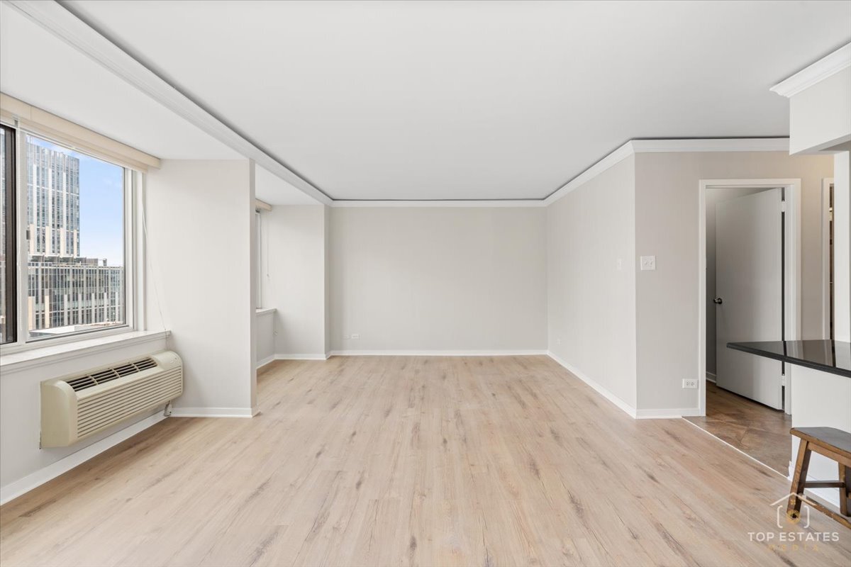 211 East Ohio Street, Unit 2806 Chicago, IL 60611 - Photo 7 of 33 a view of an empty room with a window and wooden floor