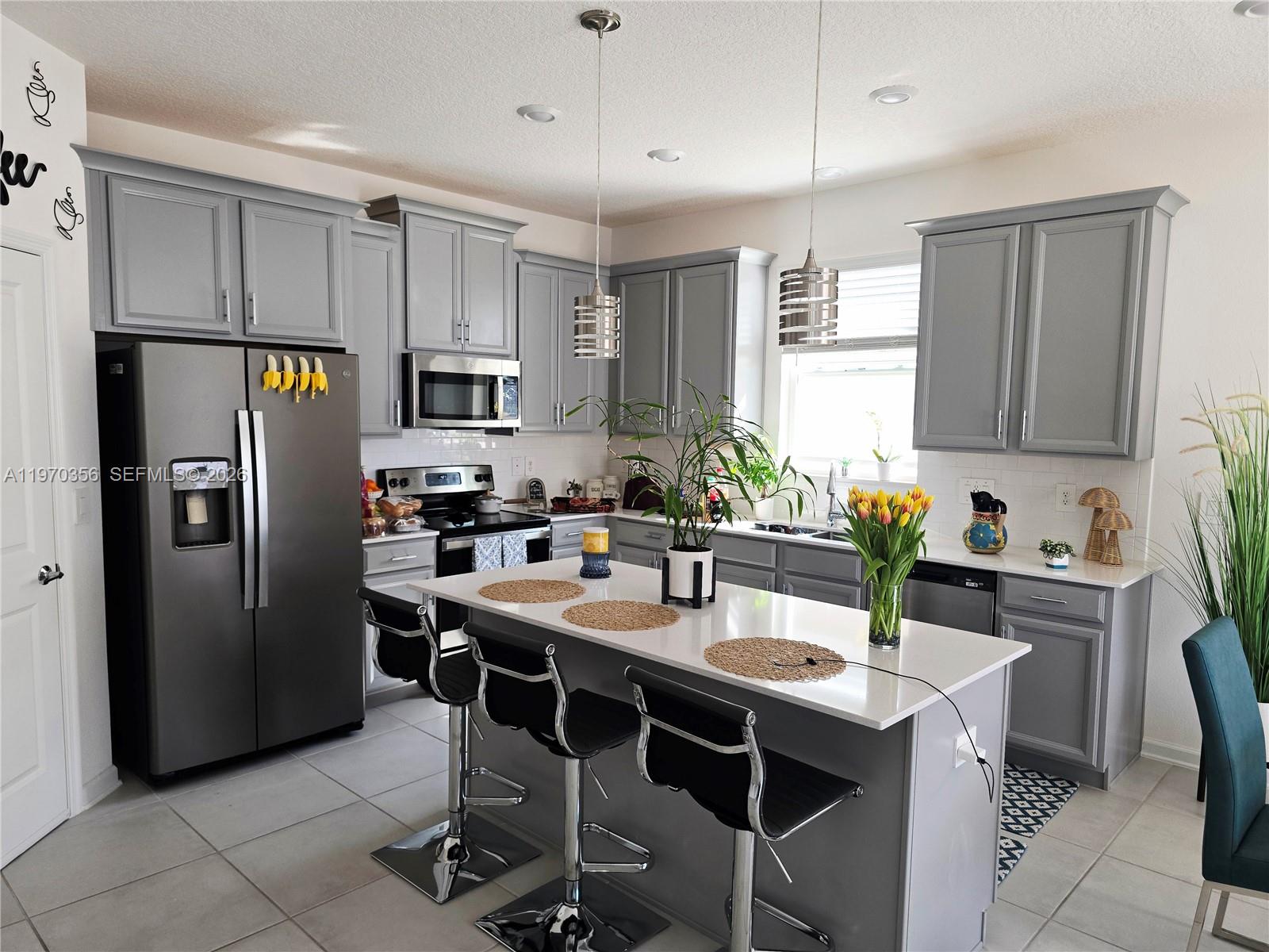 815 Kapi Drive Groveland, FL 34736 - Photo 23 of 30 a kitchen with stainless steel appliances granite countertop a refrigerator a sink a stove a dining table and chairs