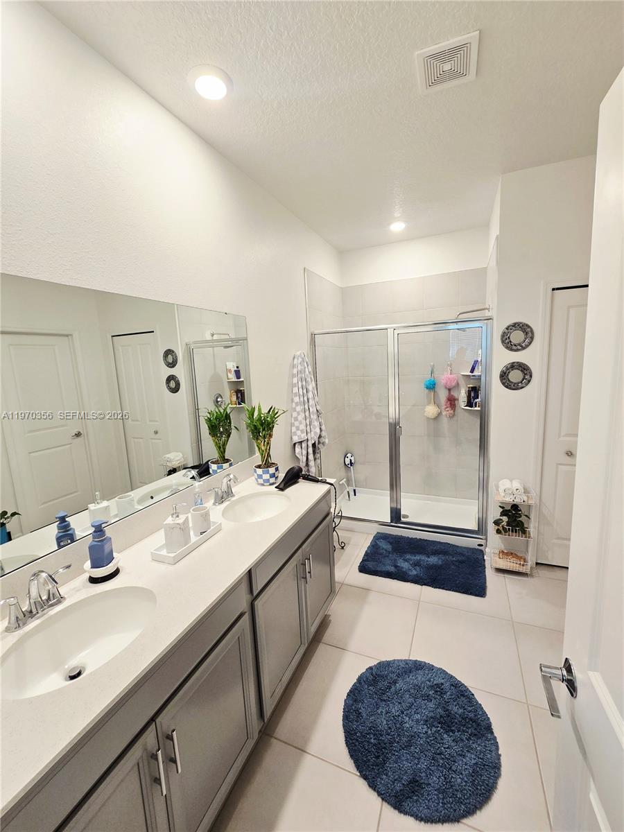 815 Kapi Drive Groveland, FL 34736 - Photo 27 of 30 a spacious bathroom with a double vanity sink a mirror and shower