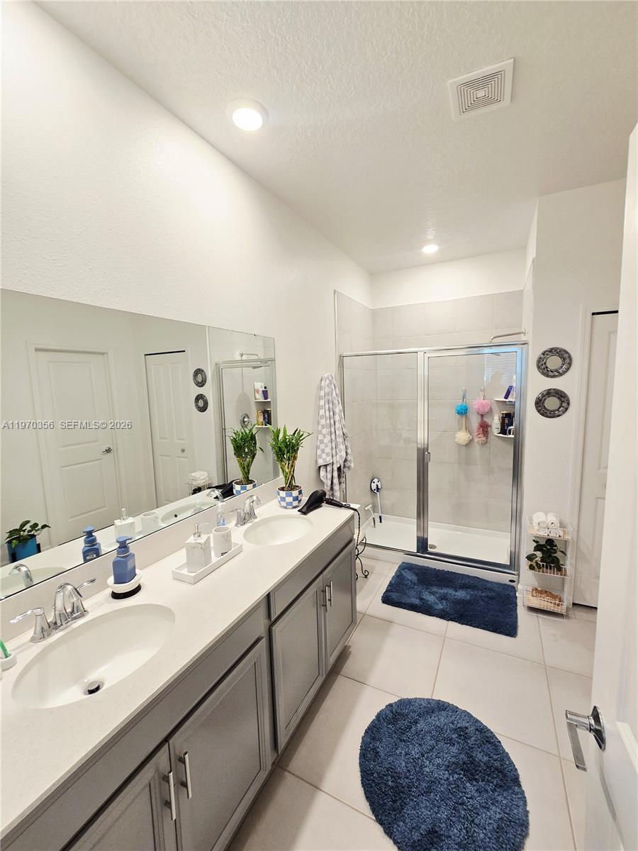 815 Kapi Drive Groveland, FL 34736 - Photo 28 of 30 a spacious bathroom with a double vanity sink a mirror and a shower