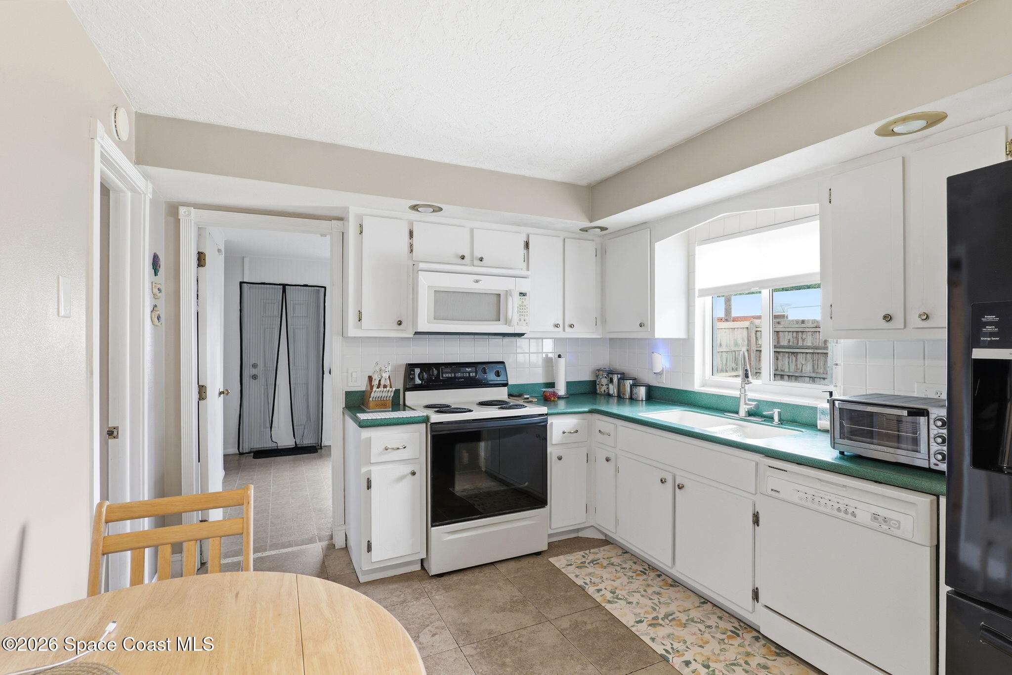 908 Jefferson Road Rockledge, FL 32955 - Photo 13 of 37 a kitchen with stainless steel appliances granite countertop a stove a sink and a refrigerator