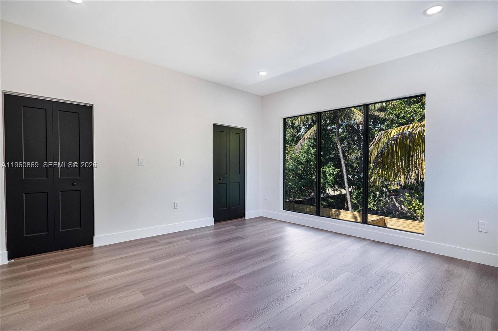 281 Northwest 52nd Street, Unit 281 Miami, FL 33127 - Photo 32 of 52 a view of an empty room with wooden floor and a window