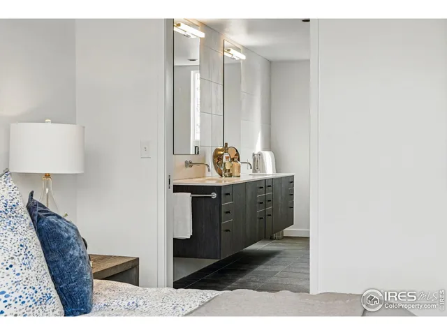 a en suite bathroom with a granite countertop sink and a mirror