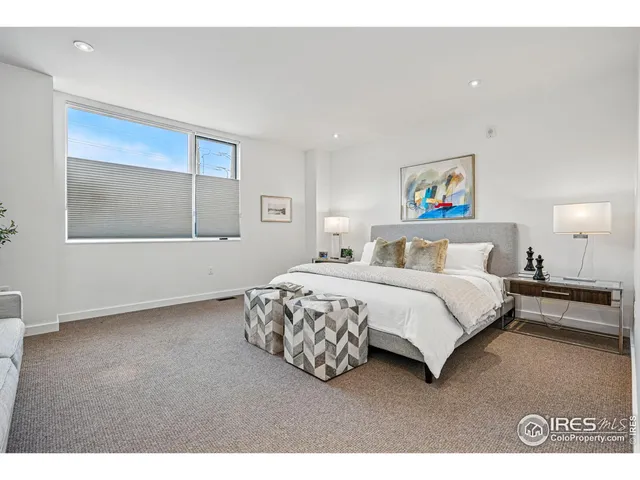 a bedroom with a bed and a painting on the wall