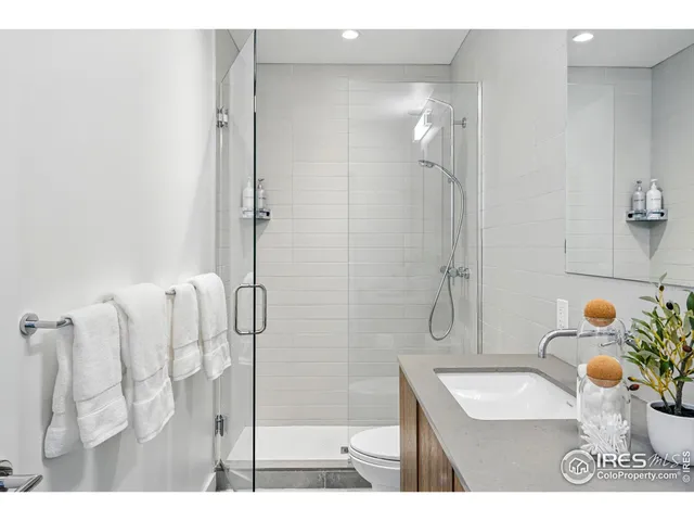 a bathroom with a sink mirror and shower