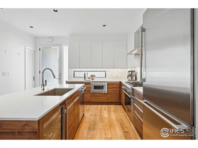 a kitchen with kitchen island a counter top space a sink stainless steel appliances and cabinets