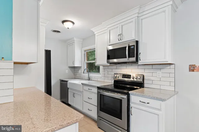 a kitchen with a stove a sink and a microwave
