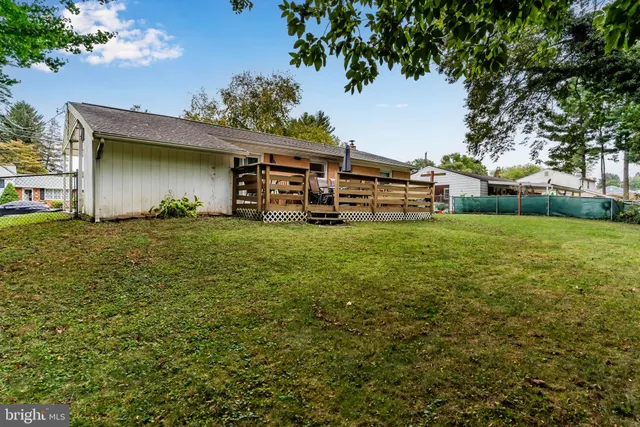 a view of a house with a big yard and large trees