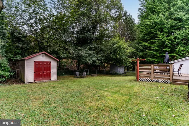 a yellow house with a big yard and large trees