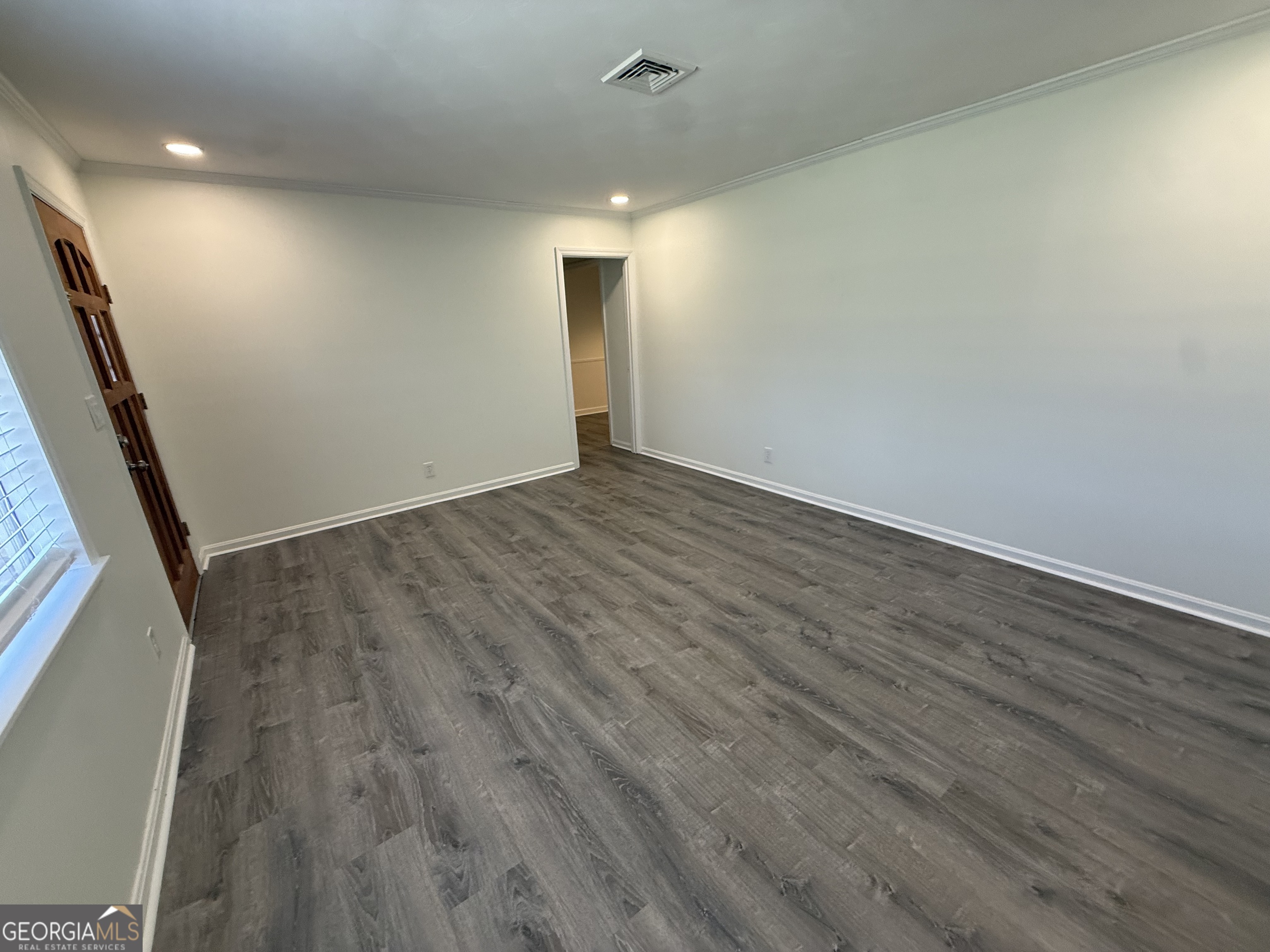108 Plum Street Dublin, GA 31021 - Photo 12 of 33 an empty room with wooden floor and windows