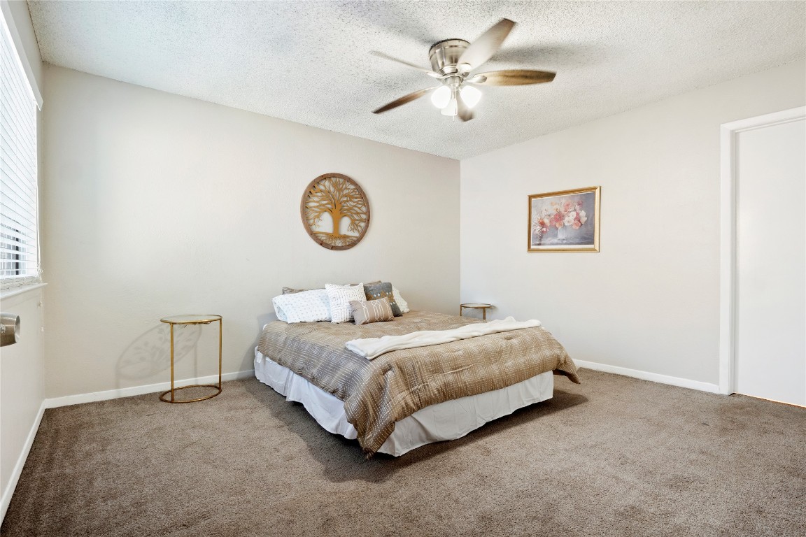 3222 Tamarron Boulevard, Unit A Austin, TX 78746 - Photo 11 of 28 a bedroom with a bed and a chandelier
