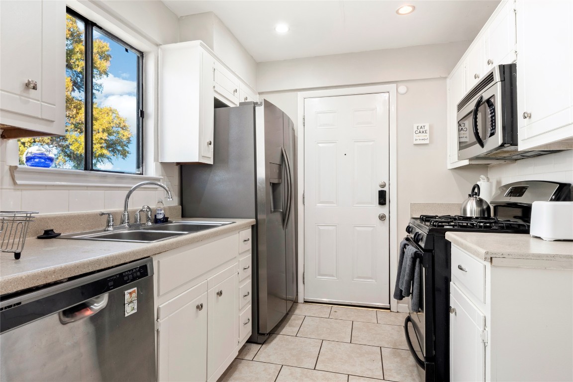 3222 Tamarron Boulevard, Unit A Austin, TX 78746 - Photo 8 of 28 a kitchen with stainless steel appliances granite countertop a sink stove and refrigerator