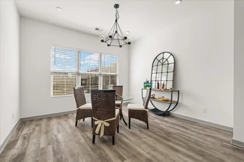 a view of a dining room with furniture a chandelier and wooden floor