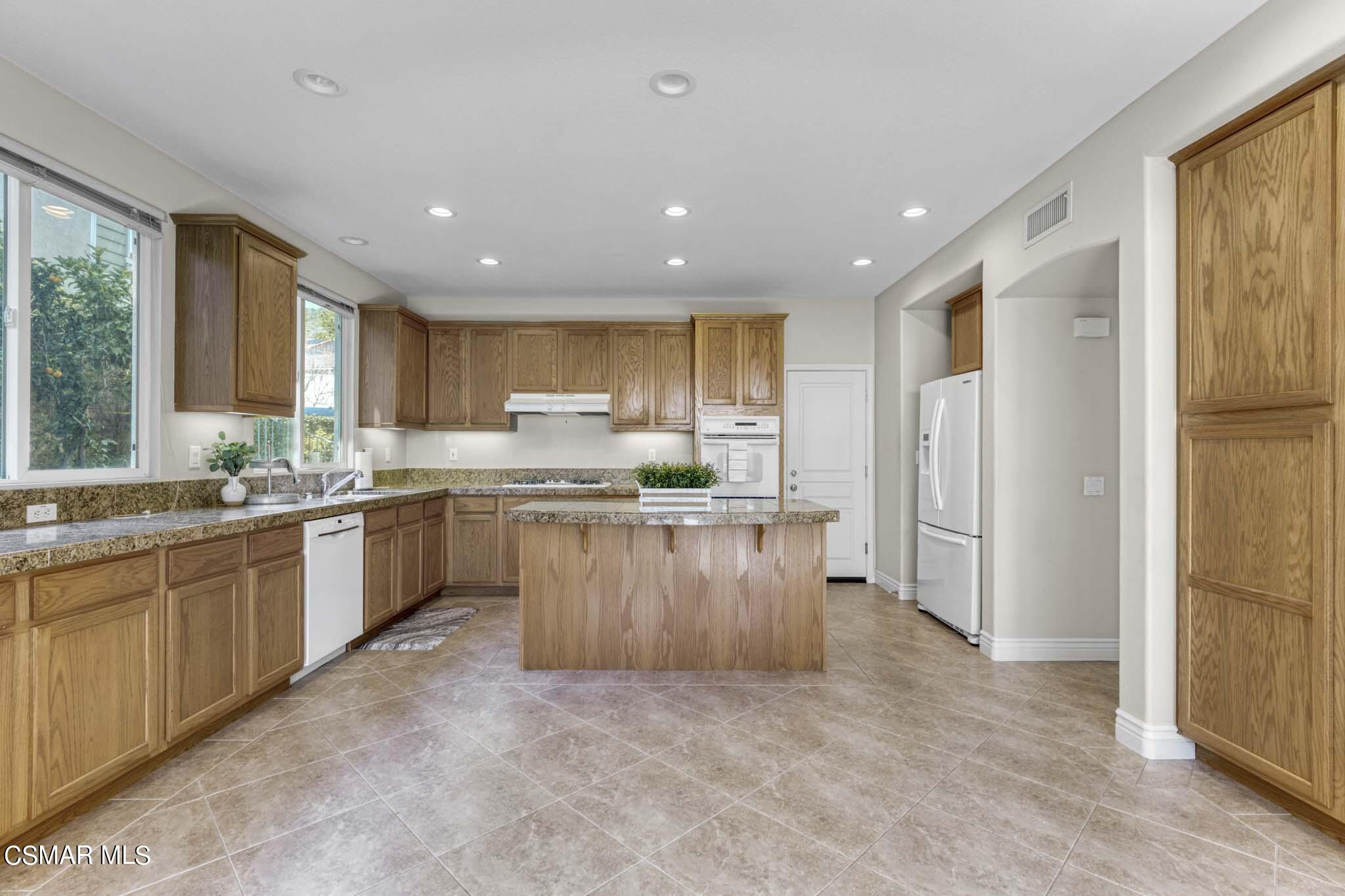 476 Woodland Road Simi Valley, CA 93065 - Photo 15 of 41 a kitchen with stainless steel appliances granite countertop a refrigerator a sink dishwasher a stove and a refrigerator with wooden floor