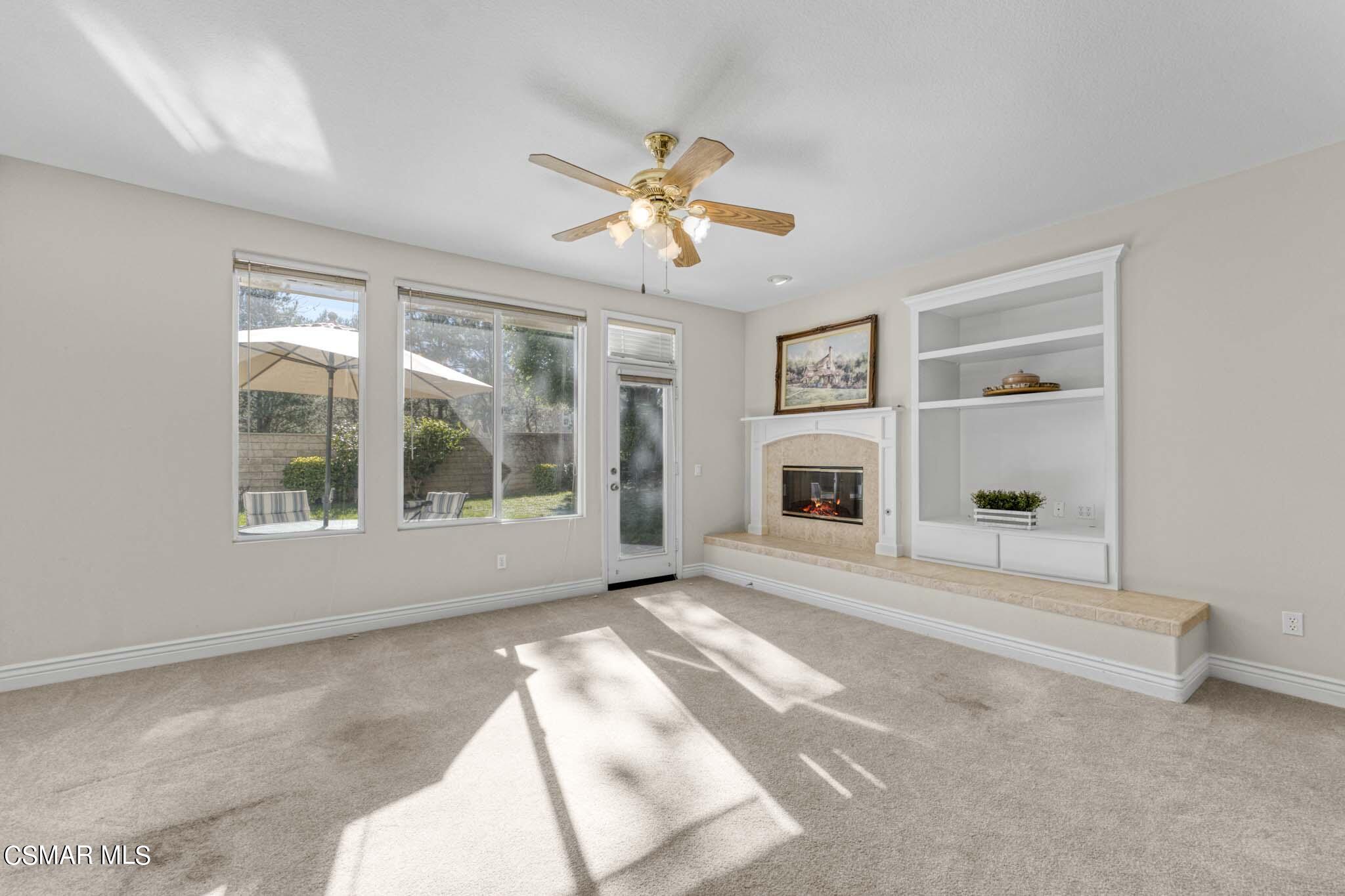 476 Woodland Road Simi Valley, CA 93065 - Photo 19 of 41 a view of a livingroom with a fireplace a ceiling fan and windows