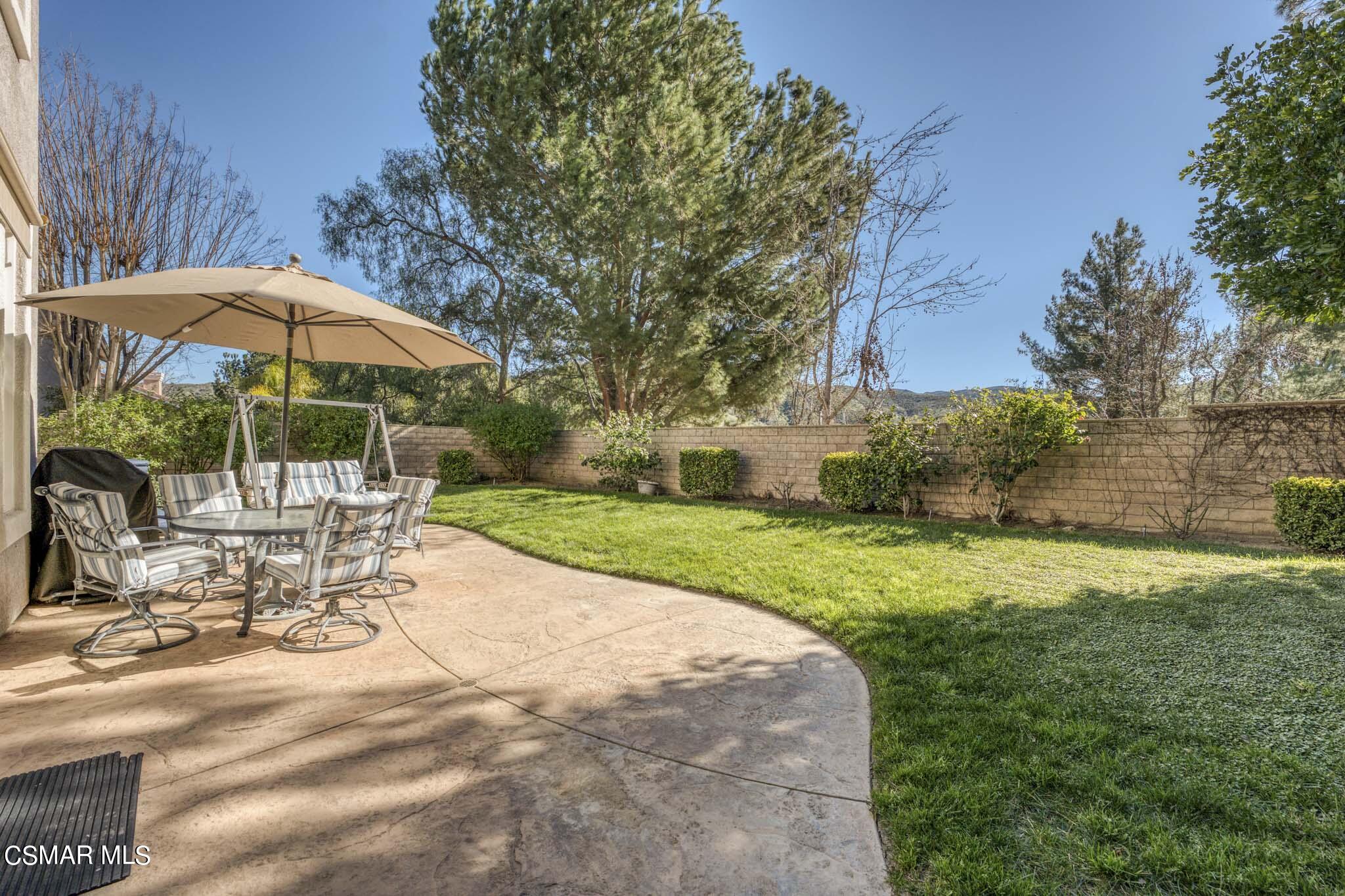 476 Woodland Road Simi Valley, CA 93065 - Photo 38 of 41 a view of a patio with a table and chairs under an umbrella