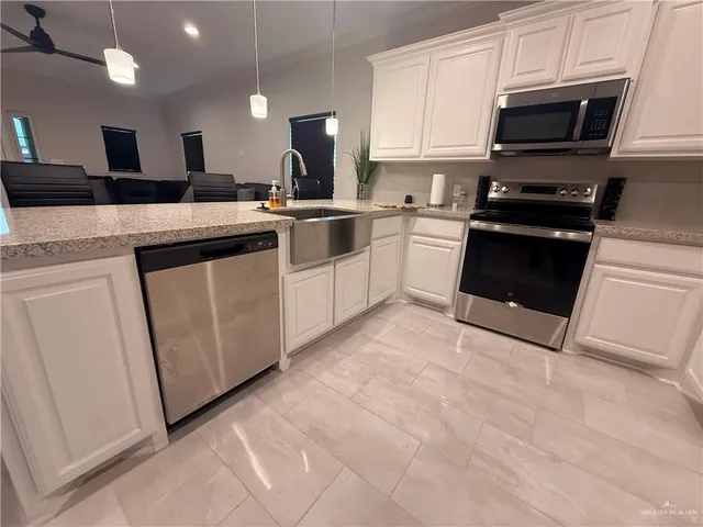 a kitchen with white cabinets and appliances