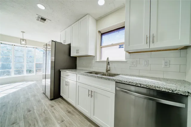 a kitchen with stainless steel appliances granite countertop a sink stove and refrigerator
