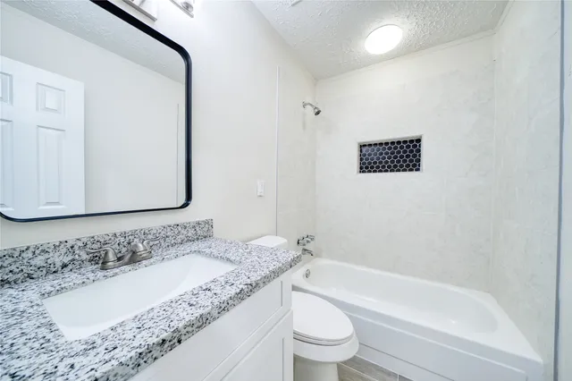 an empty room with wooden floor ceiling fan and windows