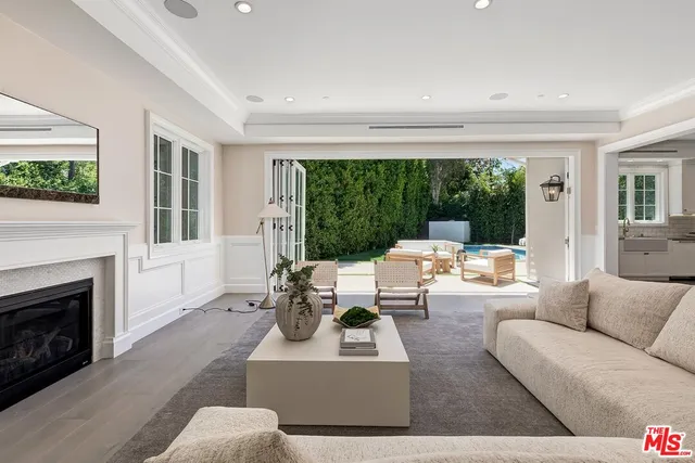 a living room with furniture a fireplace and a large window