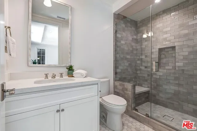 a spacious bathroom with a shower sink and mirror