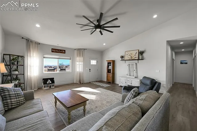 a kitchen with stainless steel appliances granite countertop a refrigerator a sink dishwasher a stove and white cabinets with wooden floor