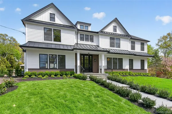 a front view of a house with a yard and green space