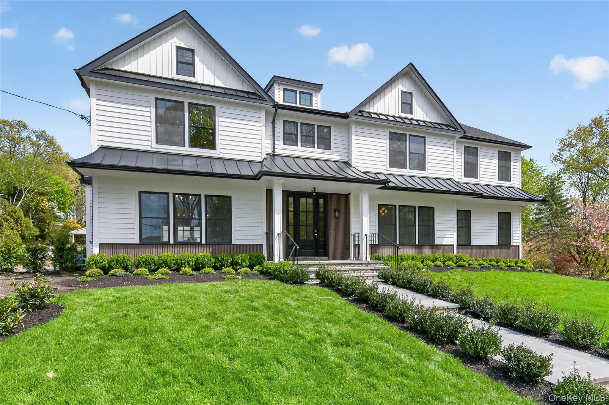 a front view of a house with a yard and green space