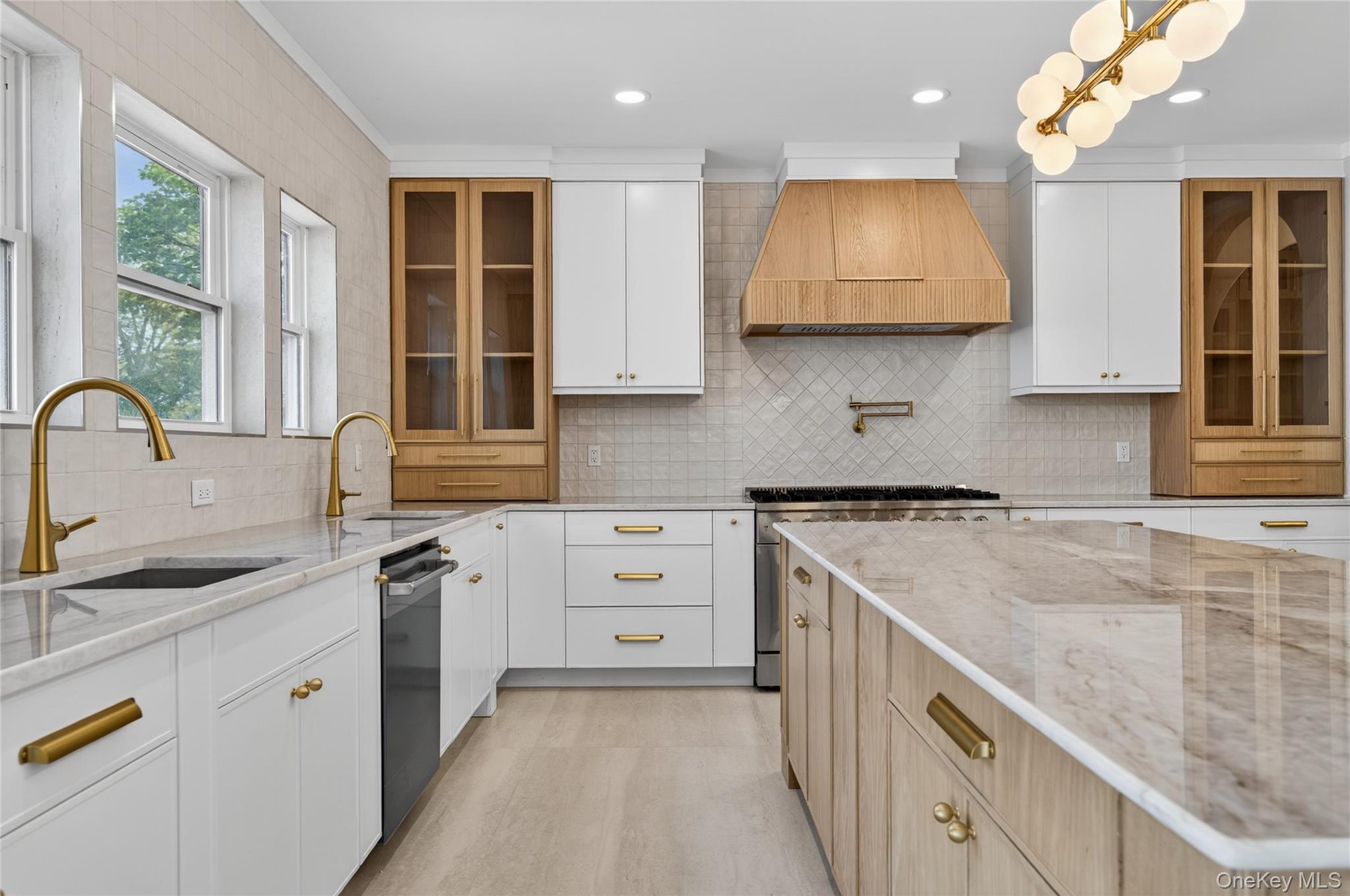 15 Ridge Drive Port Washington, NY 11050 - Photo 11 of 46 a kitchen with white cabinets a sink a stove and a window
