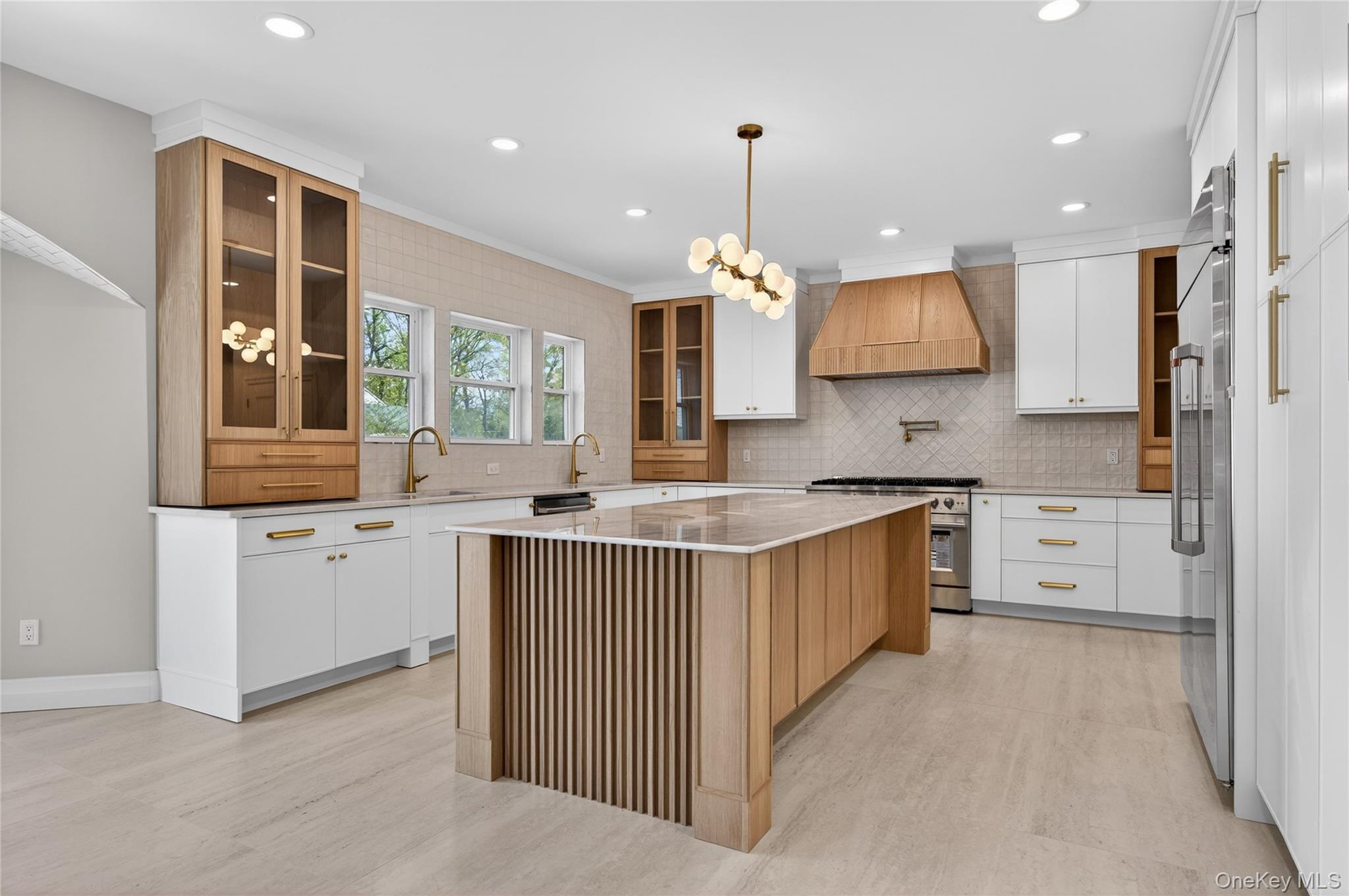 15 Ridge Drive Port Washington, NY 11050 - Photo 12 of 46 a kitchen with stainless steel appliances granite countertop a sink stove and refrigerator