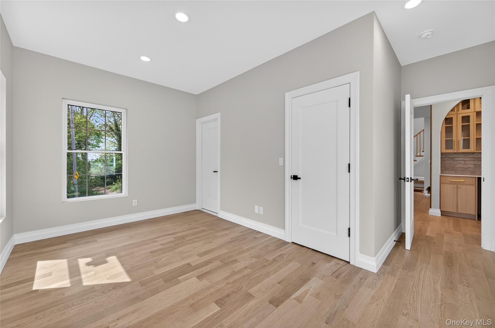 15 Ridge Drive Port Washington, NY 11050 - Photo 19 of 46 an empty room with wooden floor and windows