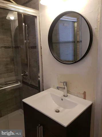 a bathroom with a sink a mirror and a shower