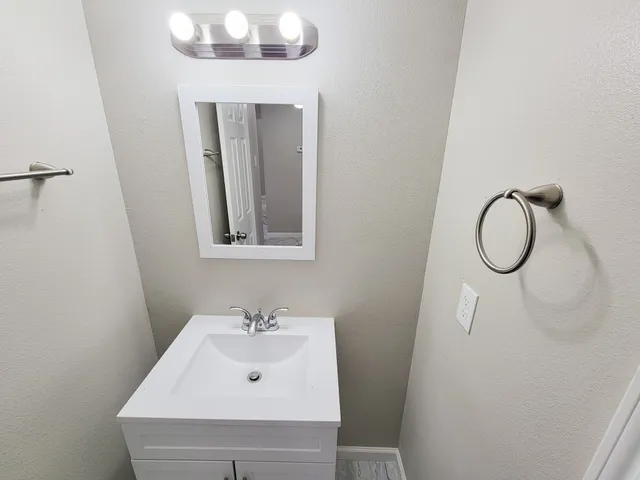 a bathroom with a sink a toilet a vanity and shower